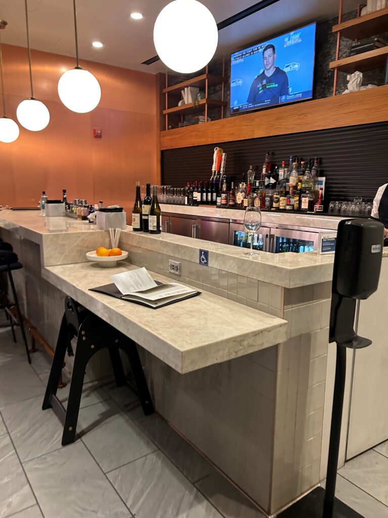 a bar with bottles and a television on the wall