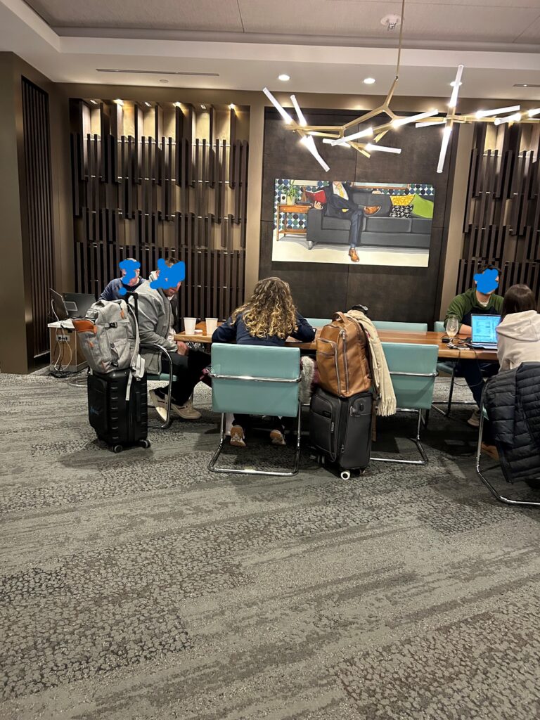 a group of people sitting at a table with luggage