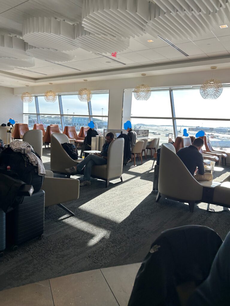 a group of people sitting in chairs in a room with large windows