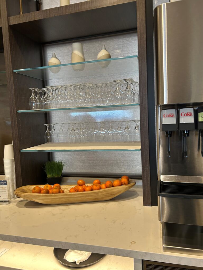 a shelf with glasses and fruit in a bowl