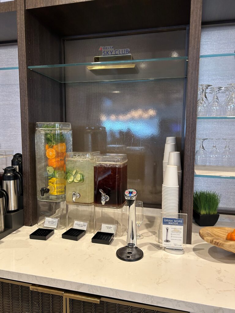 a glass shelf with different drinks and cups on it