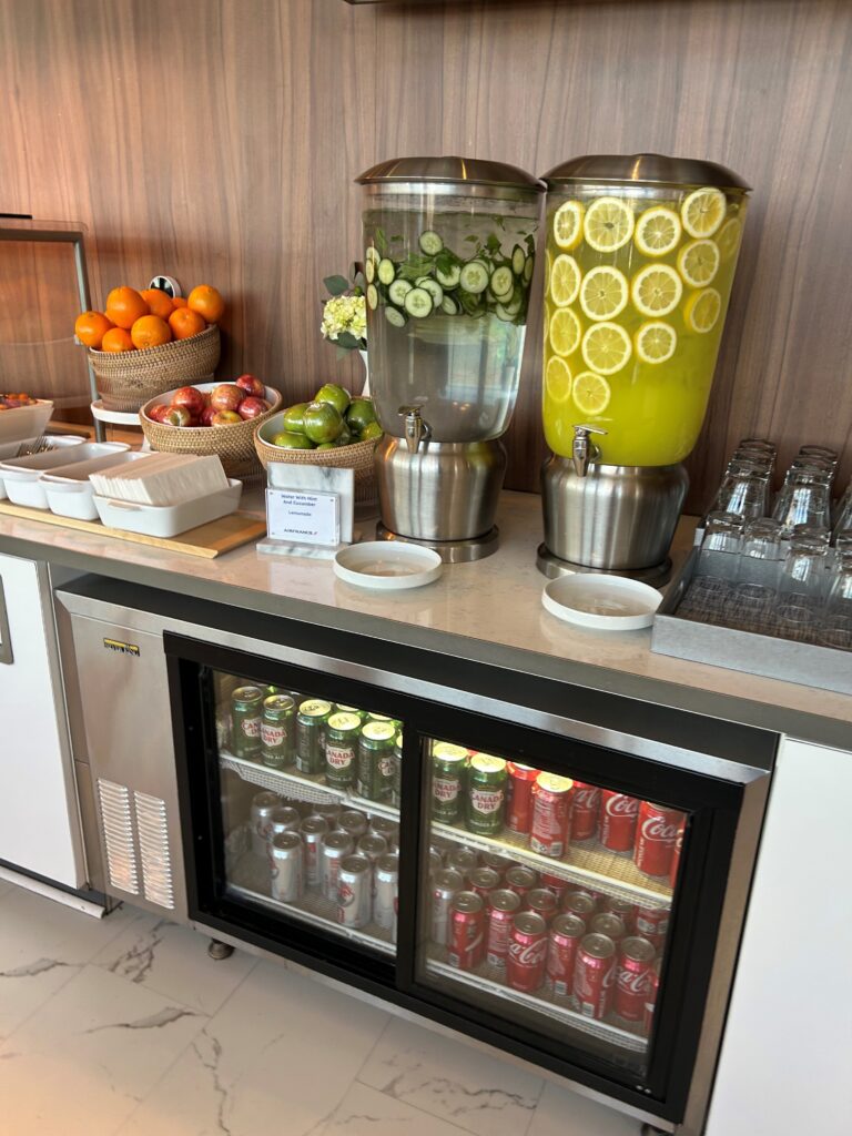 a beverage dispenser with fruit and vegetables on a counter