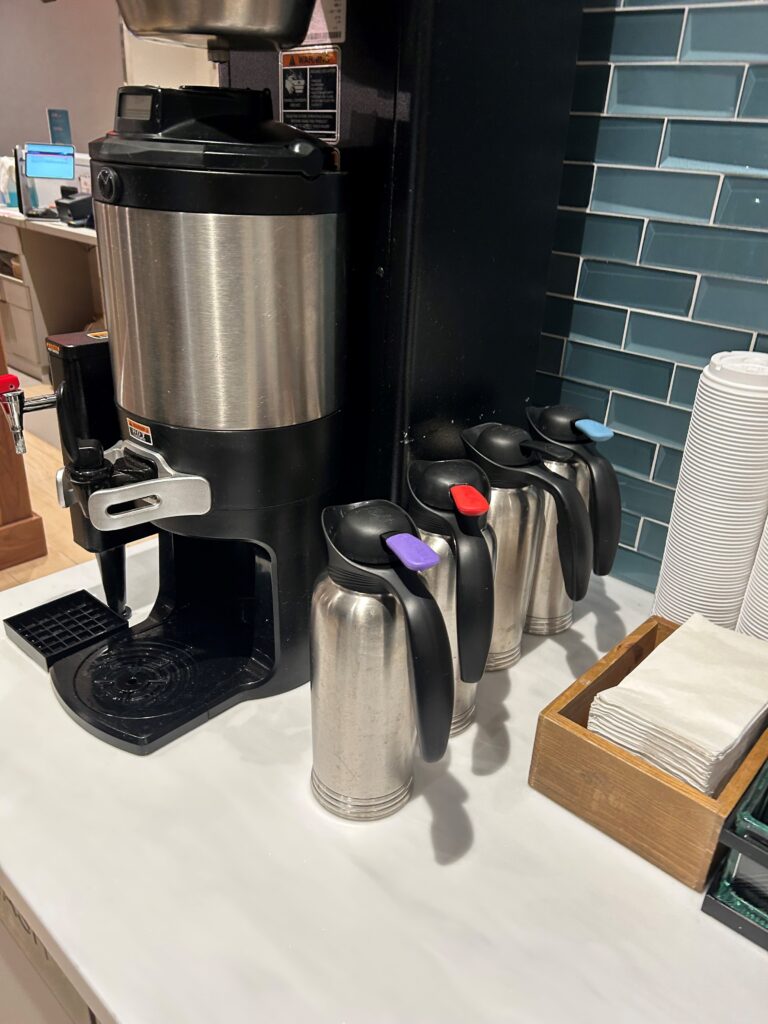 a coffee maker and coffee cans on a counter